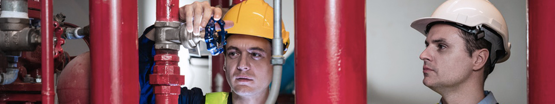 Engineer adjusting industrial valve system in pipeline facility